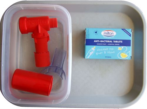 POWERbreathe being disinfected using a plastic container filled with water, to which an anti-bacterial tablet has been added