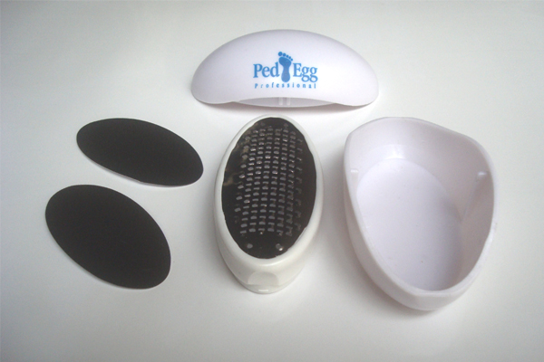 Picture of the Ped Egg components (left to right) consisting of two emery boards, the metal file, protective cover and the waste container that holds the exfoliated skin